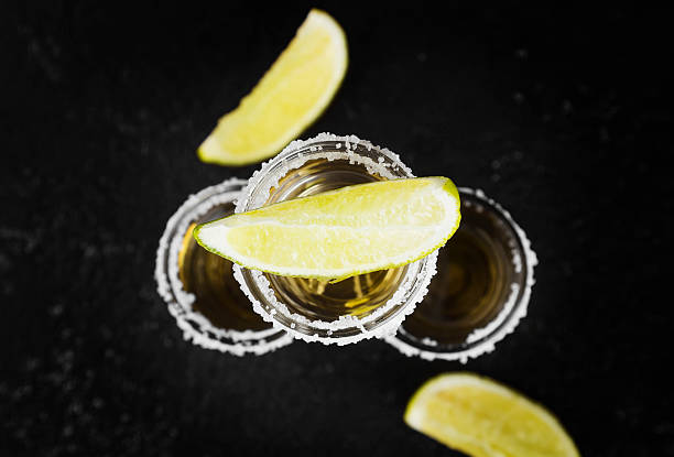 istock Tequila with salt and lime on a dark background. Toning 625555612