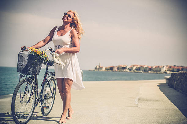 Mature woman riding bicycle Mature woman riding bicycle older women short skirts stock pictures, royalty-free photos & images