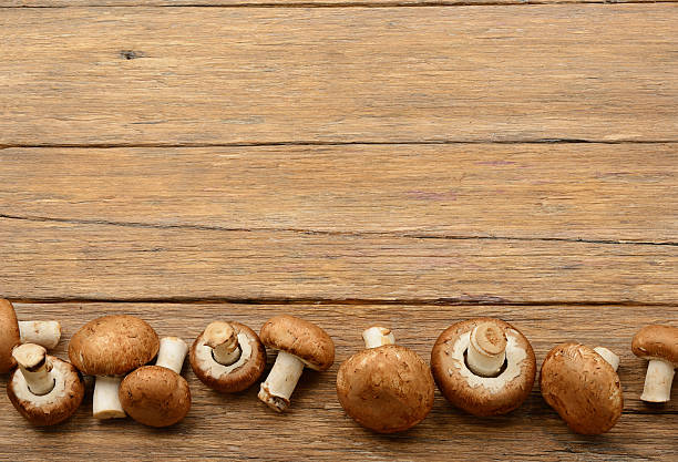 istock Champignon mushrooms on old wooden table. Top view. 625590726