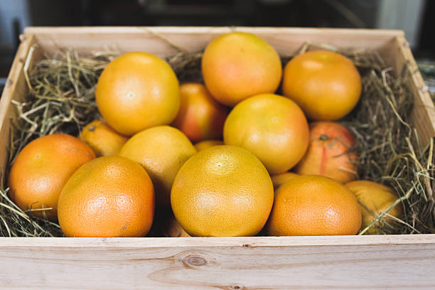istock Wooden box with fresh ripe grapefruits in fruit shop 625597254