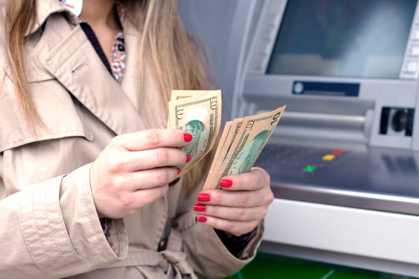 istock Woman taking cash from ATM 625607772