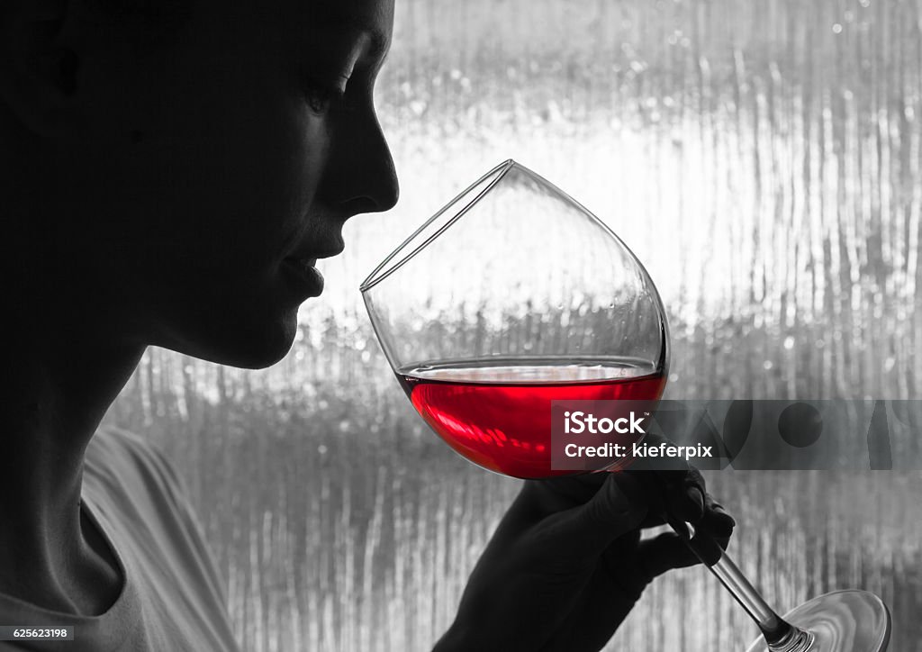 Woman tasting wine Woman tasting glass of red wine. Alcohol - Drink Stock Photo