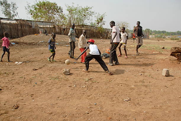 i bambini giocano a calcio in una strada di juba, sud sudan. - africa south africa child african culture foto e immagini stock
