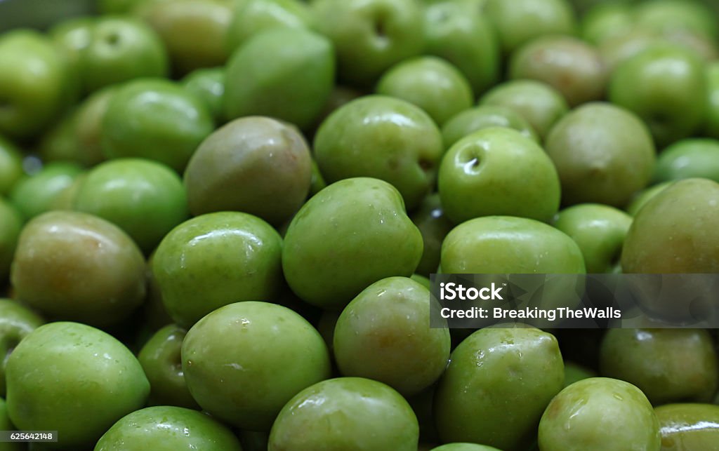 Green whole olives close up background Green whole castelvetrano olives close up background, retail market stall display Business Stock Photo