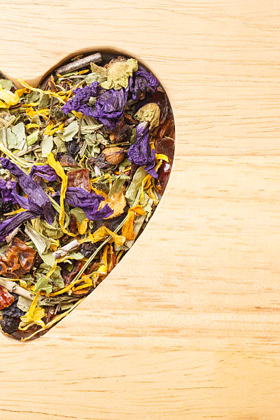 istock Dried herb leaves heart shaped on wooden surface 625653088