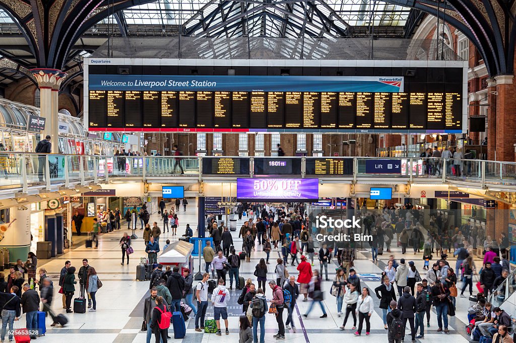 Liverpool Street Station in London, United Kingdom Main entrance hall of Liverpool Street train station in London, UK. People are rushing by, train destinations are shown on the arrival/departure board. Liverpool Street station serves as a major train and subway hub in the East of the City of London, horizontal orientation, England, UK. Railroad Station Stock Photo
