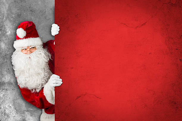 istock santa claus looking behind empty concrete billboard sign wall 625660974