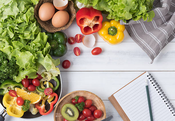 istock Fresh salad vegetables and fruit with notebook and pencil 625669294