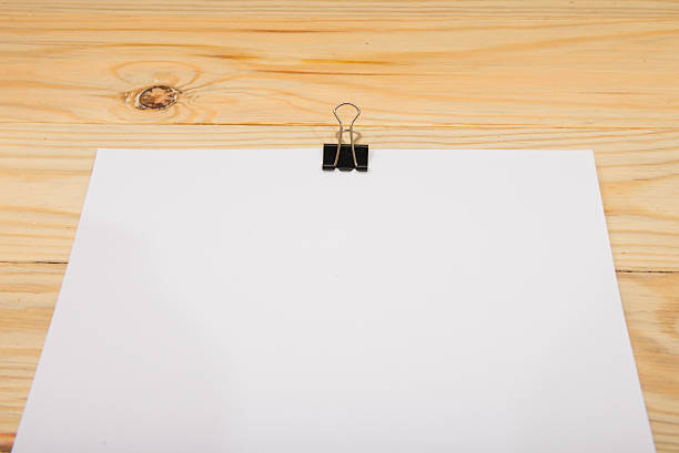 istock Black clip and White blank note paper hang on wood 625669744