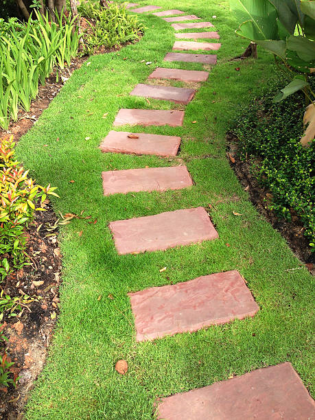 istock red sand stone pathway on grass in garden 625670794