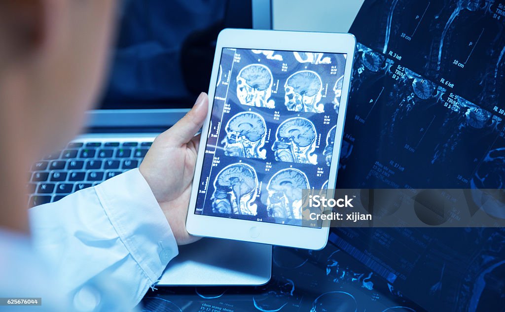 médico que revisa la radiografía con tabletas - Foto de stock de Radiólogo libre de derechos