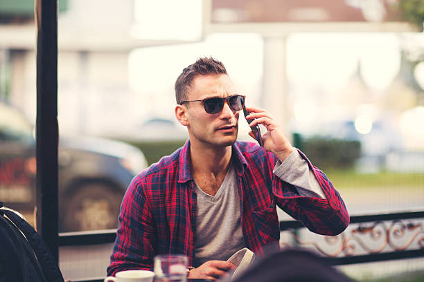 istock Young man sitting in cafe using phone 625685872