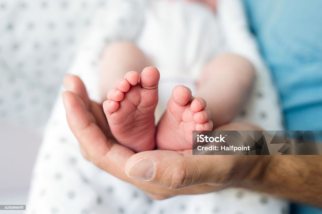 Père méconnaissable avec un fils nouveau-né, des jambes et une main - Photo de Bébé libre de droits