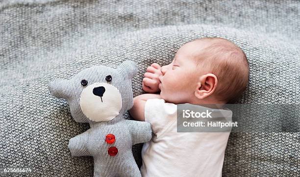 Newborn Baby Boy Lying On Bed With Teddy Bear Sleeping Stock Photo - Download Image Now