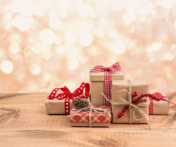 istock Christmas gift boxes on wooden table over abstract lights background 625686696