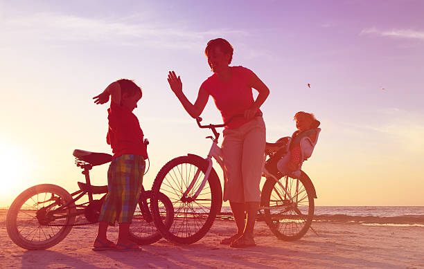 istock happy mother with two kids biking at sunset 625686714