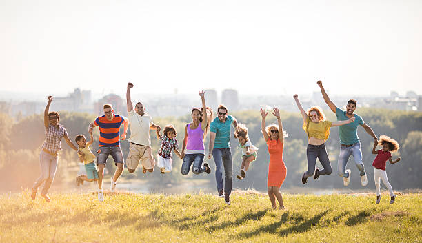 istock Group of happy people jumping in nature with hands raised. 625687462