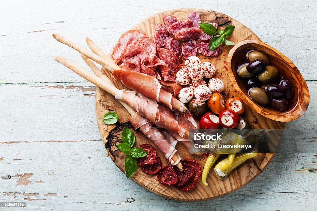 Antipasto Platter Antipasto Platter Cold meat plate with grissini bread sticks on wooden background Antipasto Stock Photo