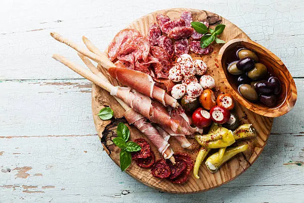 Antipasto Platter Cold meat plate with grissini bread sticks on wooden background
