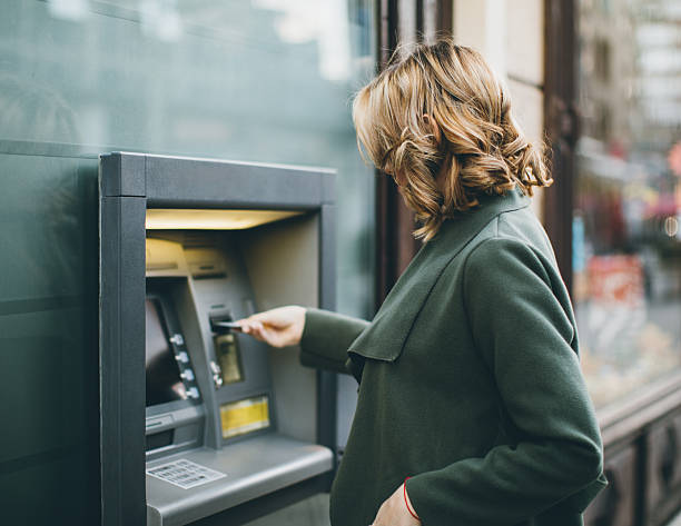 mujer joven con cajero automático - banking bill women human hand fotografías e imágenes de stock
