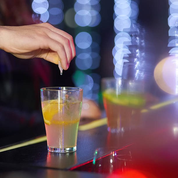 Closeup shot of a man drungs into a drink in a nightclub