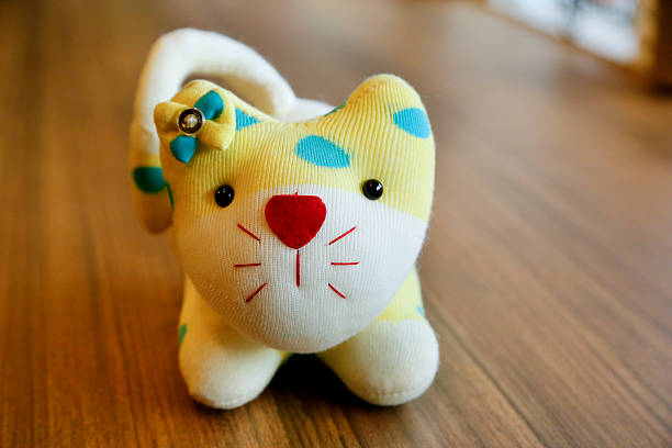 istock Funny handmade toy cat isolated on brown background. 625699168