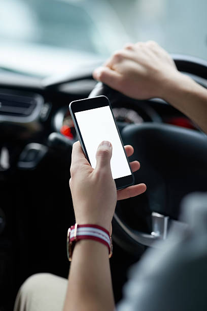 Distracted driving is a potential danger Closeup shot of an unrecognisable man using his cellphone while driving Distracted stock pictures, royalty-free photos & images