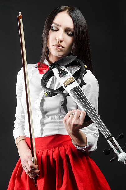 istock Calm woman playing the violin on a black background 625704002