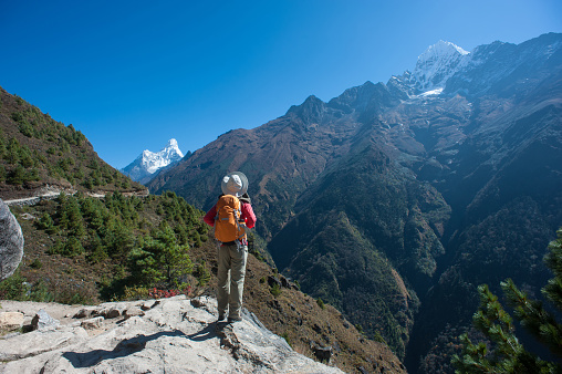 young woman backpacker trekking on himalaya mountains