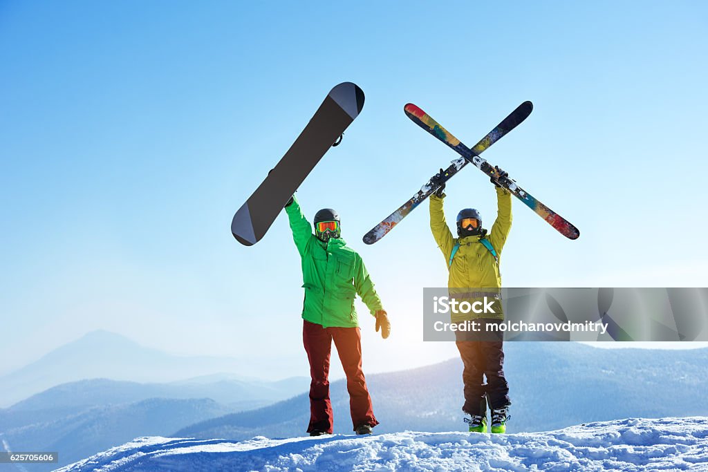 Skier and snowboarder mountain top Skier and snowboarder stands mountain top with ski and snowboard in hands. Skiing and snowboarding concept. Sheregesh ski resort Skiing Stock Photo