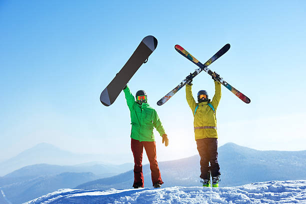 Skier and snowboarder mountain top Skier and snowboarder stands mountain top with ski and snowboard in hands. Skiing and snowboarding concept. Sheregesh ski resort snowboard stock pictures, royalty-free photos & images