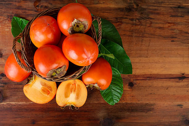 istock Persimmon fruits in wicker basket. Top view. 625706366