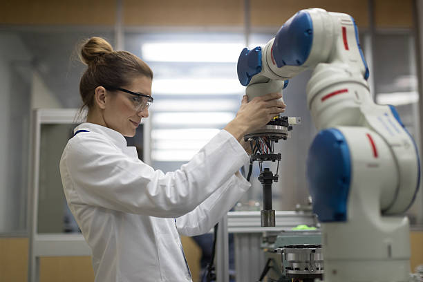ingegneri donne che lavorano con il braccio robotico - lab coat women one person female foto e immagini stock
