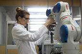 Female engineers working with robotic arm