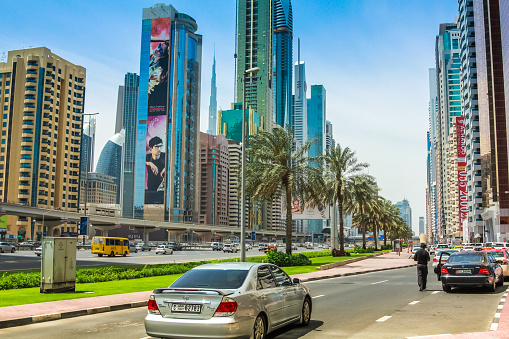 Dubai, United Arab Emirates - May 1, 2013: street view of Sheikh Zayed Road in Dubai Downtown with its modern skyscrapers and towers with billboards. Dubai financial district skyline.