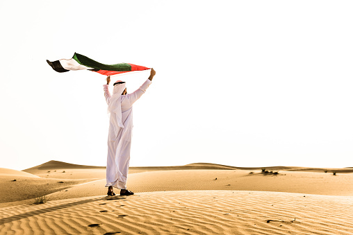 Jeque ondeando la bandera de los Emiratos Árabes Unidos para el Día Nacional photo