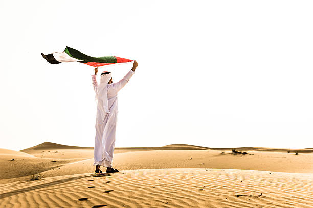 Cheik agitant le drapeau des Émirats arabes unis pour la fête nationale - Photo