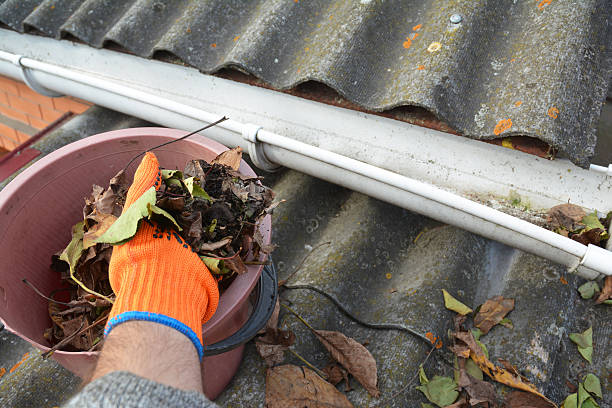 istock Rain Gutter Cleaning from Leaves. Roof Gutter Cleaning Tips. 625721828