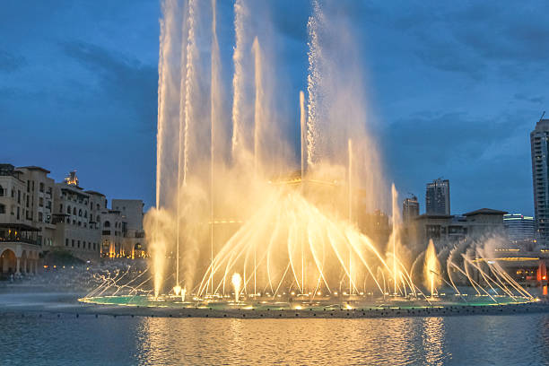 Night view of the light show at Dubai Fountain. The Dancing Fountain of Dubai performs to the beat of music near Burj Khalifa and Dubai Mall in downtown of Dubai.