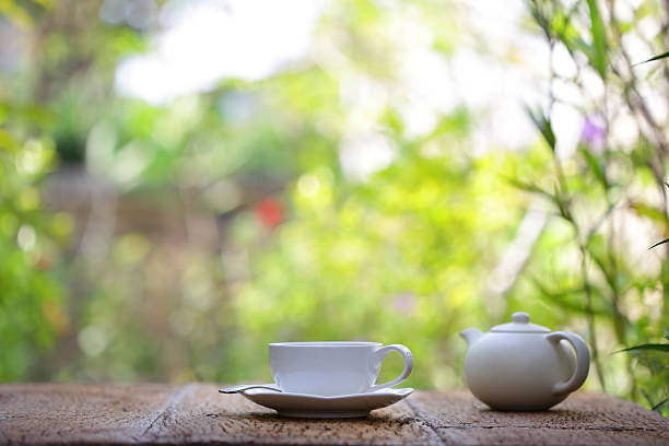 white tea cup with white teapot on wooden table