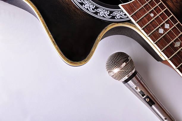 istock Acoustic guitar and microphone isolated on white table top view 625724392