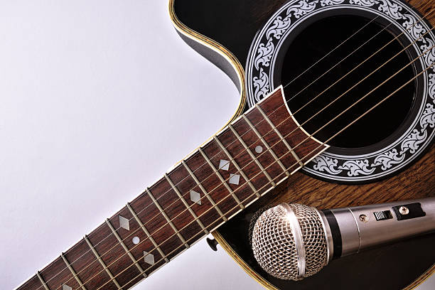 istock Acoustic guitar and microphone isolated on white table top 625724518