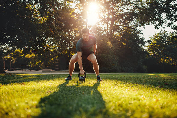 istock Fit young man exercising with kettlebell outdoors 625725554