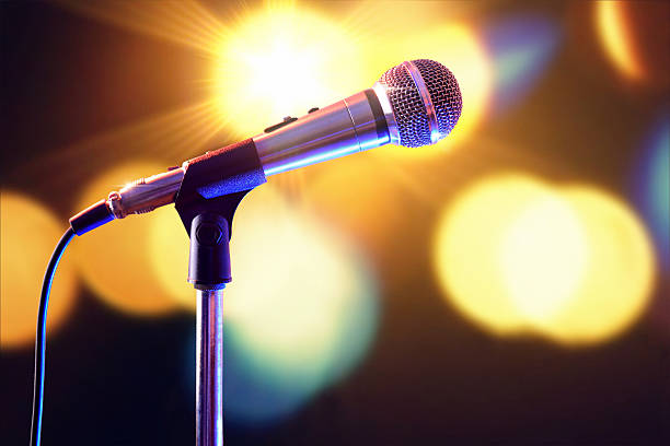 istock Microphone on microphone stand with lights in the background 625725600