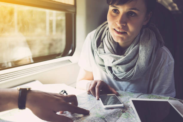 istock Young woman planning a trip, using smartphone, travelling by train 625725958