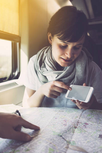 istock Young woman travelling, inside train, using smartphone 625726386