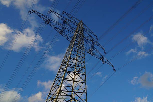 istock electricity pylon against blue sky with white clouds 625726412