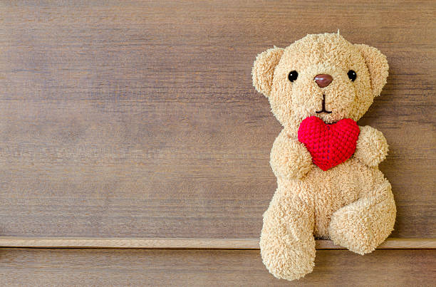istock Teddy bear holding a heart-shaped pillow 625726420