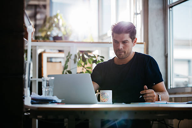 istock Handsome young businessman working at his desk 625726706