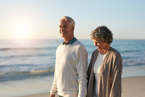 istock Happy mature couple walking along the beach 625727408